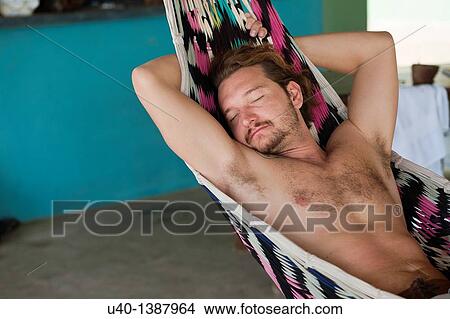 Picture - Man sleeping on hammock. Fotosearch