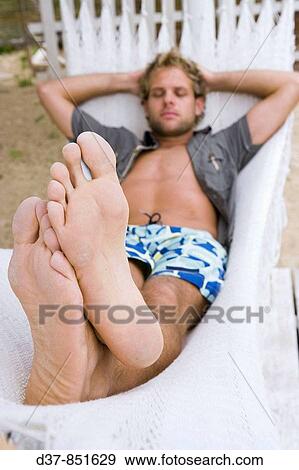 Man slepping on a hammock View Large Photo Image Stock Photo - Man slepping on a hammock. Fotosearch