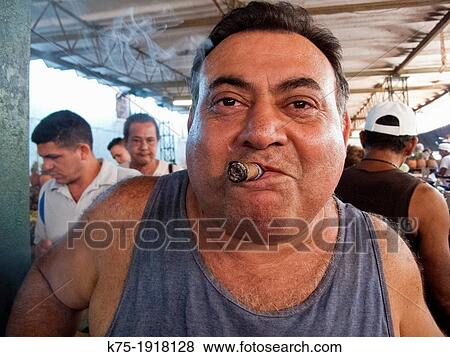 Stock Photo - Man smoking cigar in market. Fotosearch