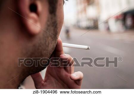Stock Photograph - Man smoking cigarette outdoors. Fotosearch
