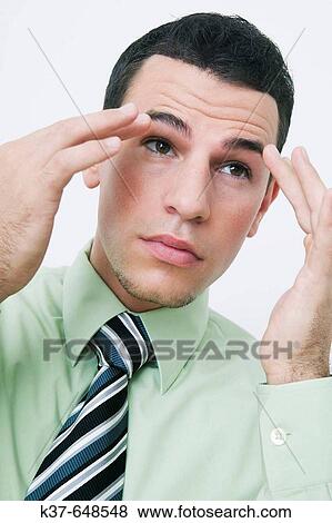 Man smoothing his eyebrows & checking himself in mirror after tying his tie & before going to work. View Large Photo Image Stock Photo - Man smoothing his eyebrows & checking himself in mirror after tying his tie & before going to work.. Fotosearch