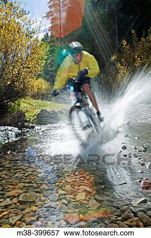 Man splashing through water on a mt. biking in Sun Valley, Idaho. USA View Large Photo Image Stock Photo - Man splashing through water on a mt. biking in Sun Valley, Idaho. USA. Fotosearch