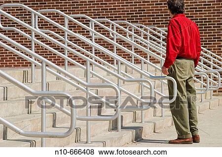 Man standing among metal hand railings. View Large Photo Image Stock Photo - Man standing among metal hand railings.. Fotosearch