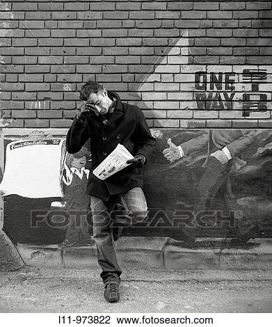 Man standing in alley; reading a newspaper. View Large Photo Image Stock Image - Man standing in alley; reading a newspaper.. Fotosearch
