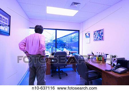 Man standing in an empty business office View Large Photo Image Stock Photograph - Man standing in an empty business office. Fotosearch