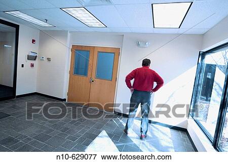 Man standing in an office building lobby. View Large Photo Image Stock Photo - Man standing in an office building lobby.. Fotosearch