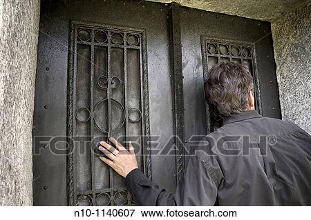 Man standing in front of double doors View Large Photo Image Stock Photo - Man standing in front of double doors. Fotosearch