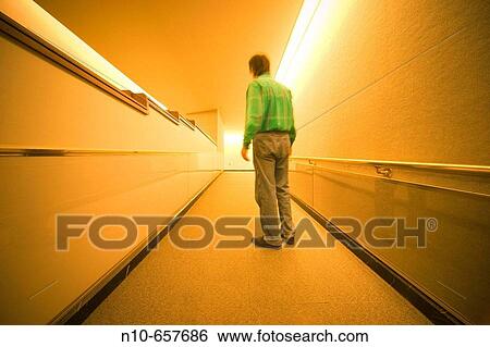 Man standing in the hallway of an office building lobby. View Large Photo Image Stock Photograph - Man standing in the hallway of an office building lobby.. Fotosearch