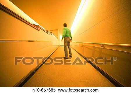 Man standing in the hallway of an office building lobby. View Large Photo Image Stock Photography - Man standing in the hallway of an office building lobby.. Fotosearch