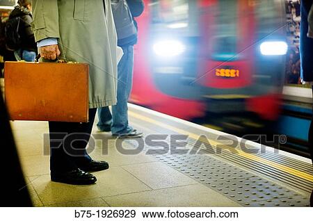 man standing with briefcase in hand on the platform of underground in London, England, UK View Large Photo Image Stock Photo - man standing with briefcase in hand on the platform of underground in London, England, UK. Fotosearch