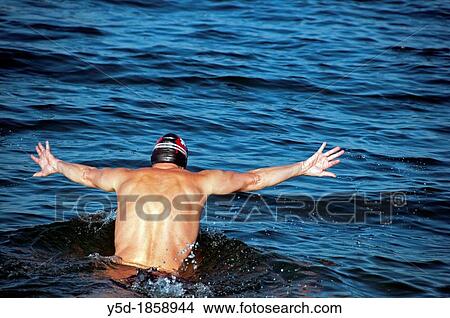 Picture - man starting to swim in waters of Lake Geneva, middle of November, Switzerland. Fotosearch