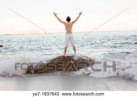 Man Stood On Rock on The Beach View Large Photo Image Stock Image - Man Stood On Rock on The Beach. Fotosearch