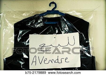 Stock Photo - Man suit inside a clear plastic bag, hanging on a hanger in a tailoring and for sale? a vendre? sign in the Medina of Fez, Morocco, Africa.. Fotosearch