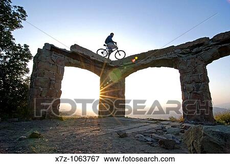 Man sunset mountain biking at Knapps Castle in the Santa Ynez Mountains above the city of Santa Barbara in southern California USA View Large Photo Image Stock Photo - Man sunset mountain biking at Knapps Castle in the Santa Ynez Mountains above the city of Santa Barbara in southern California USA. Fotosearch