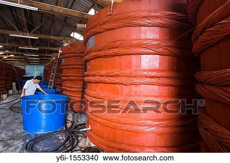 Man supervises large vats of fermenting fish sauce at factory Phu Quoc Island Vietnam View Large Photo Image Stock Image - Man supervises large vats of fermenting fish sauce at factory Phu Quoc Island Vietnam. Fotosearch