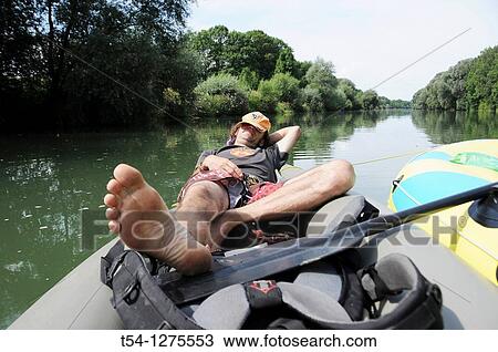 Stock Image - Man taking a nap on a boat. Fotosearch
