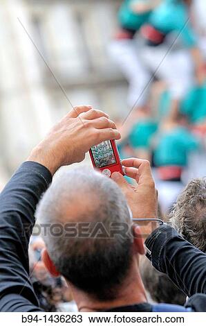 Man taking a photograph at the? Castellers?, Typical human towers in Catalonia. La Merce feast. Sant Jaume square. Barcelona, Catalonia, Spain View Large Photo Image Stock Image - Man taking a photograph at the? Castellers?, Typical human towers in Catalonia. La Merce feast. Sant Jaume square. Barcelona, Catalonia, Spain. Fotosearch