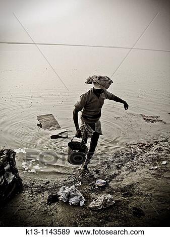 Man taking water from the Ganges river Varanasi banaras Uttar Pradesh India View Large Photo Image Stock Photo - Man taking water from the Ganges river Varanasi banaras Uttar Pradesh India. Fotosearch