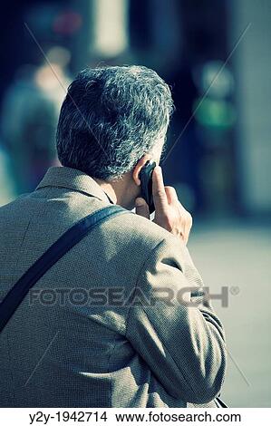 Man talking on phone with white hair, and Prince of Wales jacket. Valencia City, Spain. View Large Photo Image Picture - Man talking on phone with white hair, and Prince of Wales jacket. Valencia City, Spain.. Fotosearch