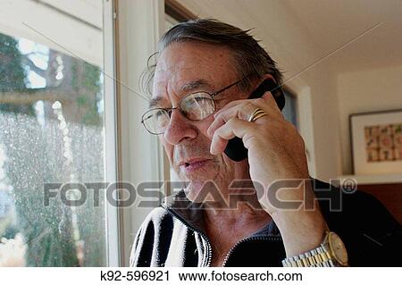 Man talking on the phone in front of a window View Large Photo Image Stock Image - Man talking on the phone in front of a window. Fotosearch