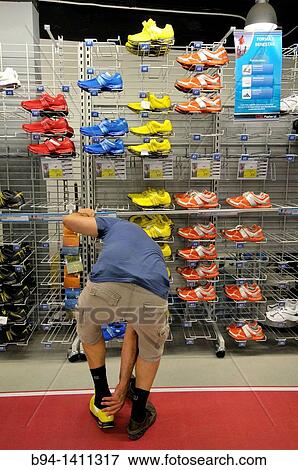 Man trying on sneakers in a sporting goods store, Barcelona, Catalonia, Spain. View Large Photo Image Stock Photo - Man trying on sneakers in a sporting goods store, Barcelona, Catalonia, Spain.. Fotosearch