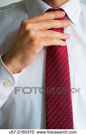 Stock Image - Man tying his tie. Close view.. Fotosearch