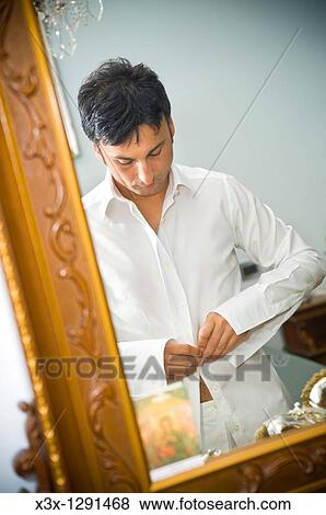 Man tying up a shirt View Large Photo Image Stock Photo - Man tying up a shirt. Fotosearch