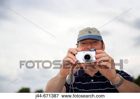 Stock Photo - Man using digital camera outdoors, Key Largo, Florida, USA. Fotosearch