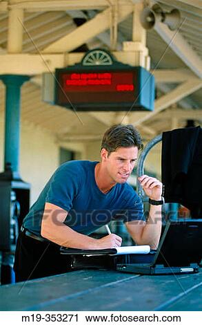 man using lap top in a train station View Large Photo Image Stock Image - man using lap top in a train station. Fotosearch