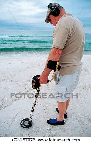 Stock Photograph - Man using metal detector. Panama City beach, Florida. USA. Fotosearch