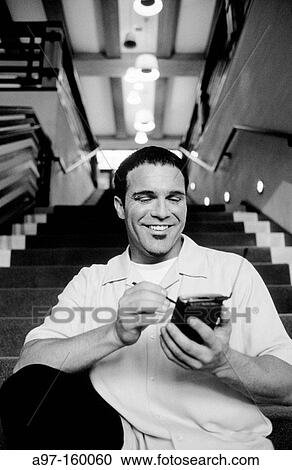 Stock Image - Man using pocket p. c. Fotosearch