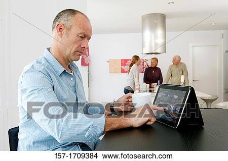 Man using tablet computer at home View Large Photo Image Picture - Man using tablet computer at home. Fotosearch
