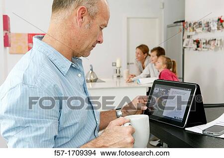 Man using tablet computer at home View Large Photo Image Picture - Man using tablet computer at home. Fotosearch