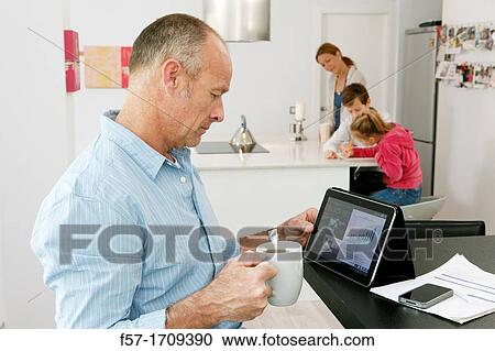 Man using tablet computer at home View Large Photo Image Stock Image - Man using tablet computer at home. Fotosearch