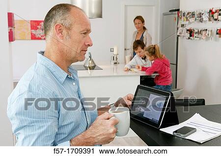 Man using tablet computer at home View Large Photo Image Stock Image - Man using tablet computer at home. Fotosearch