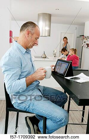 Man using tablet computer at home View Large Photo Image Stock Image - Man using tablet computer at home. Fotosearch