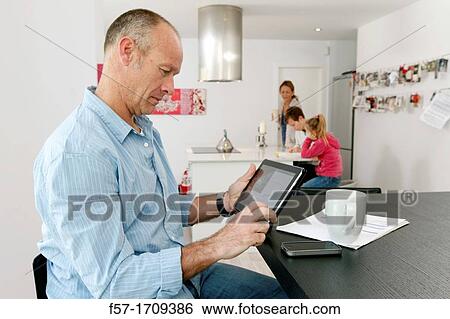 Man using tablet computer at home View Large Photo Image Stock Photograph - Man using tablet computer at home. Fotosearch
