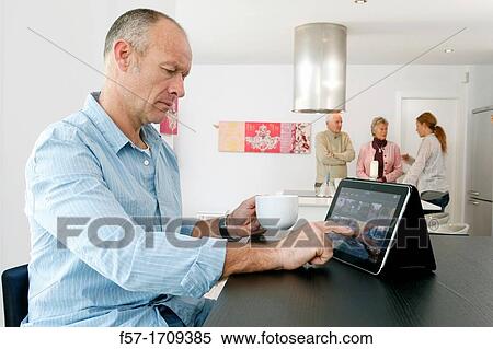Man using tablet computer at home View Large Photo Image Stock Photography - Man using tablet computer at home. Fotosearch