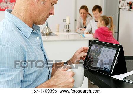 Man using tablet computer at home View Large Photo Image Stock Photography - Man using tablet computer at home. Fotosearch