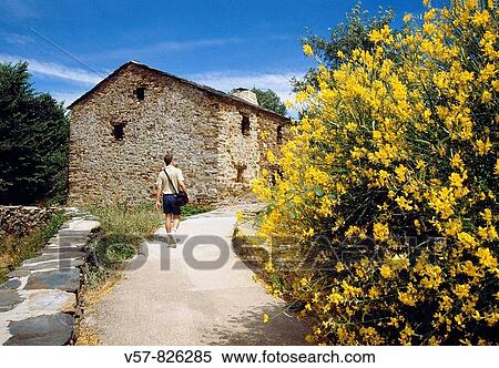 Stock Photography - Man walking along a path into the village. Umbralej, o Guadalajara province, Castilla La Mancha, Spain.. Fotosearch