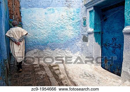 Man walking by the blue painted streets of the medina. Chefchaouen, Rif region, Morocco. View Large Photo Image Stock Photograph - Man walking by the blue painted streets of the medina. Chefchaouen, Rif region, Morocco.. Fotosearch