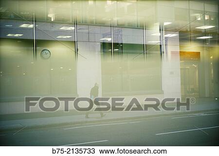 Man walking down the street, seen through a glass which a wall clock reflected in London, England, UK, Europe. View Large Photo Image Stock Image - Man walking down the street, seen through a glass which a wall clock reflected in London, England, UK, Europe.. Fotosearch