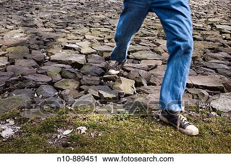 Man walking on a bed of rocks. View Large Photo Image Stock Image - Man walking on a bed of rocks.. Fotosearch
