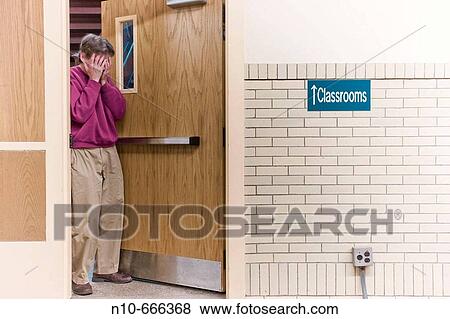 Man walking through the door in a college classroom building next to a sign reading? Classrooms?. View Large Photo Image Stock Photo - Man walking through the door in a college classroom building next to a sign reading? Classrooms?.. Fotosearch