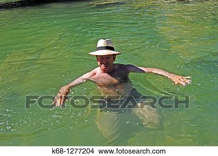 Man wearing a panama hat in the water of a creek View Large Photo Image Picture - Man wearing a panama hat in the water of a creek. Fotosearch