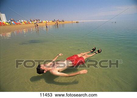 Man wearing a red bathing suit floats on his back in the Dead Sea. Israel View Large Photo Image Stock Image - Man wearing a red bathing suit floats on his back in the Dead Sea. Israel. Fotosearch