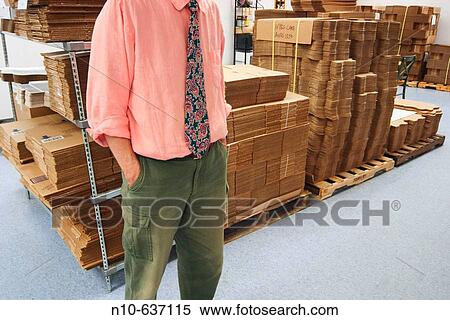 Man, wearing a tie in a factory, standing next to stacks of flat new cardboard boxes View Large Photo Image Stock Photography - Man, wearing a tie in a factory, standing next to stacks of flat new cardboard boxes. Fotosearch