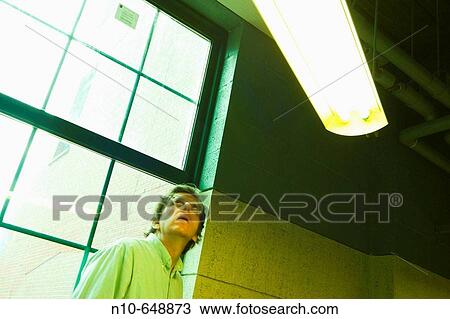 Man, wearing glasses, standing in the lobby of a building. View Large Photo Image Stock Image - Man, wearing glasses, standing in the lobby of a building.. Fotosearch