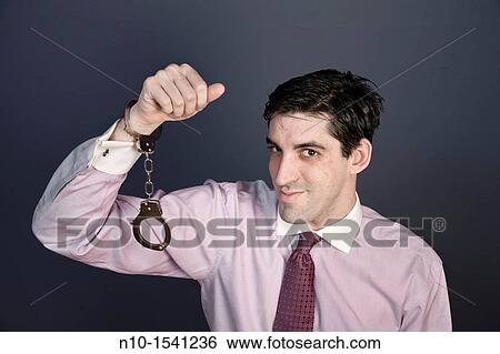 Man wearing handcuffs on one wrist View Large Photo Image Stock Photograph - Man wearing handcuffs on one wrist. Fotosearch