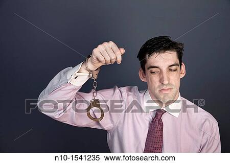 Man wearing handcuffs on one wrist View Large Photo Image Stock Photography - Man wearing handcuffs on one wrist. Fotosearch